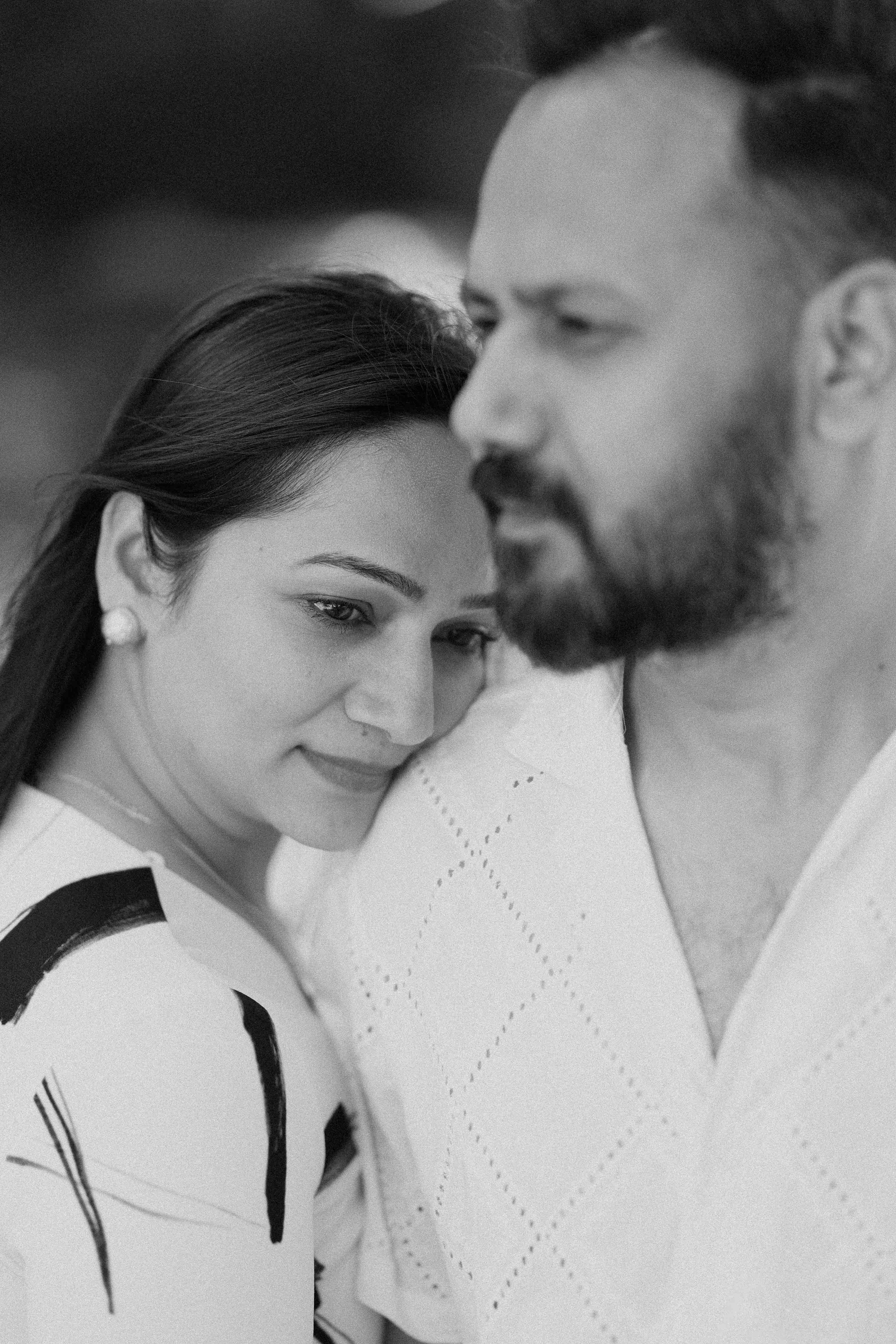 A stylishly dressed couple sitting together in a warmly lit, modern interior